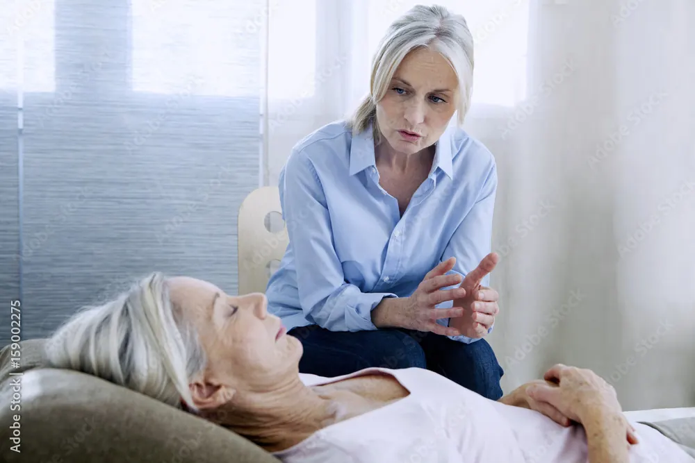 Une praticienne accompagne une personne allongée pendant une séance d’hypnose